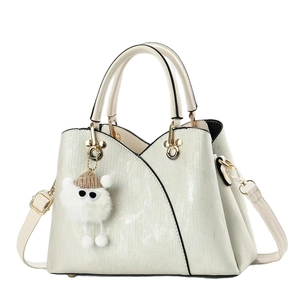 Vintage pearl white tote bag with gold hardware and plush charm on a clean white backdrop