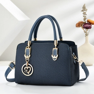 Navy blue woven leather handbag with gold heart pendant and detachable shoulder strap