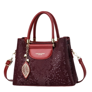 Sac à main bordeaux avec relief peau de serpent, pendentif feuille et bandoulière