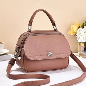 Close-up of litchi pattern leather handbag with dual zippers and clover pendant