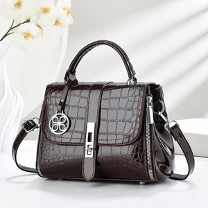 Close-up of dark brown crocodile pattern glossy handbag with silver metal lock detail