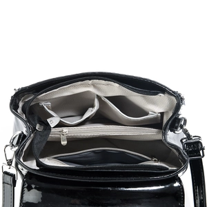 Interior view of black patent leather bag showing compartments and silver zippers