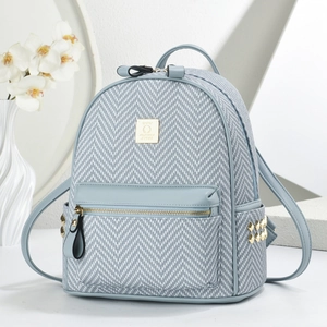 Light blue herringbone textured backpack with gold studs and front zipper pocket
