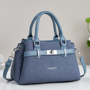 Detail of navy blue crossbody bag with silver twist lock and fashion leather texture