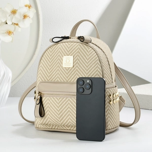 Detail of mini backpack with beige woven texture, khaki leather trim and gold studs
