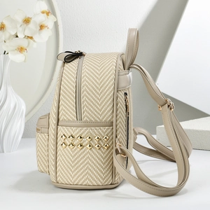 Detail of beige woven backpack with gold diamond studs and leather trim in stylish setting