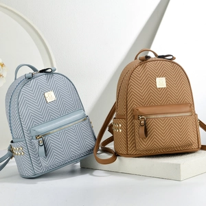 Close-up of mini backpacks with herringbone fabric, faux leather, and gold hardware details