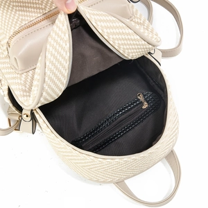 Detail view of woven backpack interior with dark lining and functional zipper pocket