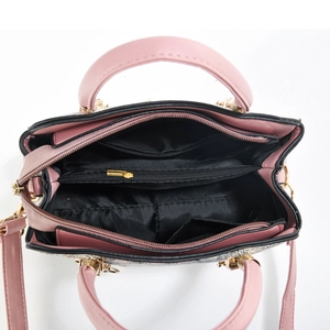 Detail view showing internal zipper compartment and pockets of the pink leather bag