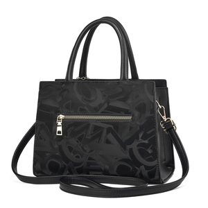 Detail of black leather handbag featuring embossed letter pattern and metal zipper pocket