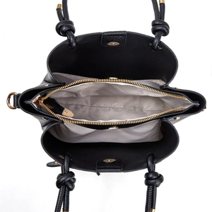 Interior view of black leather handbag with herringbone lining and gold zip compartment