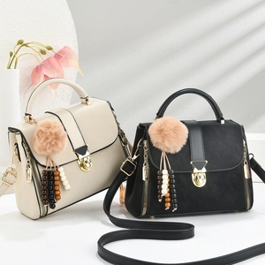 Detail of vintage tote bags with gold hardware and tassel charms in soft window light