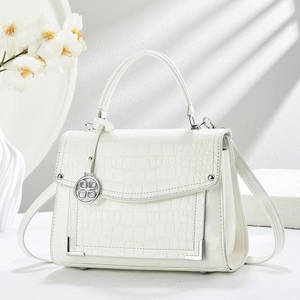 White crocodile pattern handbag with silver hardware and orchid decor in soft lighting