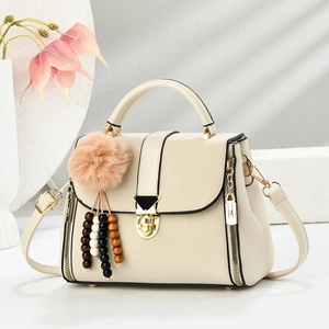 Elegant cream PU leather handbag for women with gold hardware and plush tassel detail