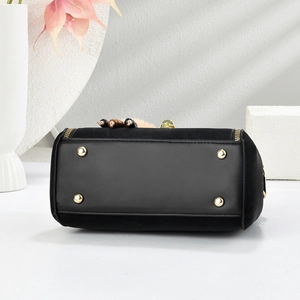 Detail of black handbag leather base featuring four protective gold metal feet and studs