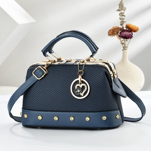 Deep blue woven texture handbag with gold accents and heart floral pendant detail
