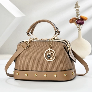 Brown textured top-handle crossbody bag with heart pendant and gold-tone hardware
