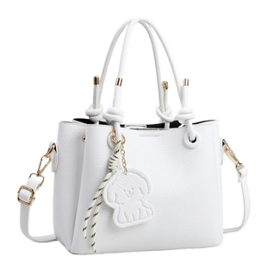 Minimalist white textured leather tote bag with knotted handles and puppy charm detail