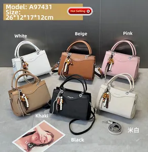 Detailansicht gewebter Handtaschen in verschiedenen Farben mit Perlenanhänger Details