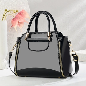 Détail d'un sac à main en cuir verni noir brillant avec fermetures dorées