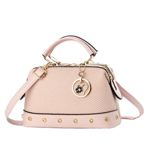 Pink woven handbag with leather trim, heart charm, and adjustable crossbody strap