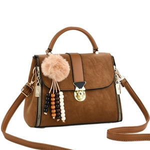 Brown vintage minimalist handbag with golden buckle and plush charm on white background