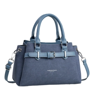 Blue denim and faux leather crossbody bag with top handles shown at a 45-degree angle