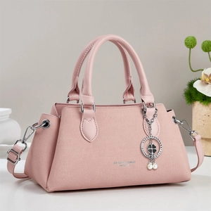 Sac à main élégant rose poudré texturé avec détails argentés et breloque trèfle