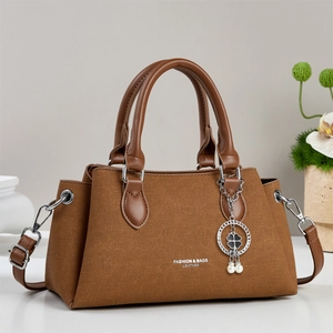 Sac cabas marron en tissu texturé avec poignées en cuir et breloque trèfle à quatre feuilles
