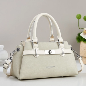 Close-up of beige handbag featuring twill texture fabric and silver metal lock details