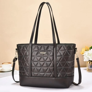 Detail of dark grey quilted tote bag with triangle stitching and adjustable strap