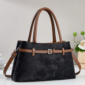 Detail view of black and brown tote bag with metal buckle and detachable shoulder strap