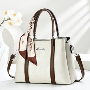 Dettaglio borsa tote vintage in pelle bianca testurizzata con logo argento e foulard in seta