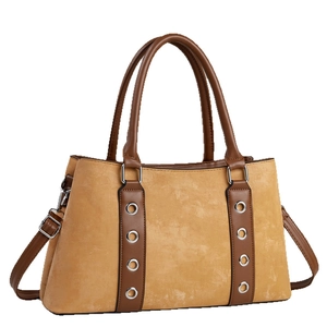 Sac à main jaune mat avec lanières en cuir marron et œillets en métal argenté sur fond blanc