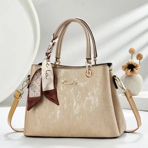Detail of elegant champagne tote bag featuring silk scarf handle and golden Fematoz logo