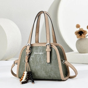 Olive green corduroy boston handbag with beige leather handles and beaded charm
