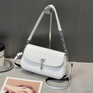Détail de la texture tressée blanche sur le sac bandoulière avec fermoir argenté tournant
