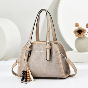 Detail of minimalist cream handbag with vertical texture and decorative wooden beaded tassel