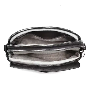 Internal view of a black pebble leather crossbody bag with triple zip compartments