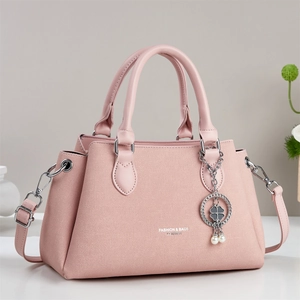 Pink faux leather trapezoid handbag with dual handles and elegant pearl clover charm