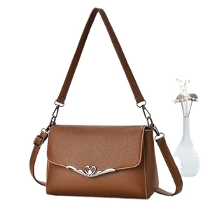 Brown litchi grain leather shoulder bag with decorative wavy flap and swan buckle