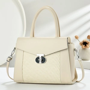 Detailed view of the mixed leather and woven texture handbag with metallic turn-lock