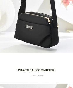 Close-up of lightweight black nylon crossbody bag with three-tier zipper compartments