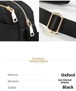 Close-up of black oxford fabric bag showing golden zippers and metal strap adjustment buckle