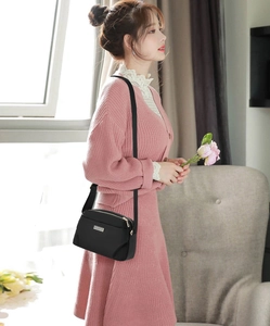 Lifestyle shot of a black nylon crossbody bag with adjustable strap worn by a model