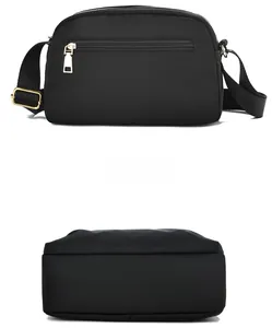 Detail view of black nylon crossbody bag featuring gold zipper pocket and adjustable strap