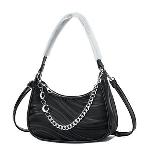 Detail of black wavy textured tote bag featuring a decorative silver chain and sleek finish
