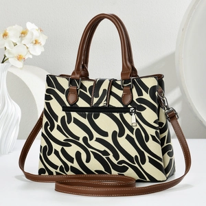 Detail of canvas tote bag back pocket with adjustable brown shoulder strap and silver hooks