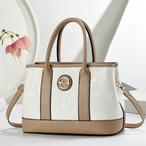 Detail view of stylish two-tone cream texture handbag with gold circular metal buckle