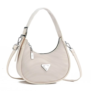 Detail view of beige hobo bag showing silver triangle plaque and chain decoration